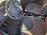 the interior of a small red car with black seats and a steering wheel