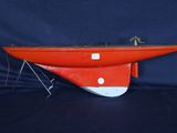 un bateau rouge et blanc posé sur une surface noire