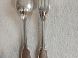 deux cuillères en argent et une fourchette posées sur une nappe blanche