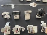 many different types of rings and bracelets laid out on a table