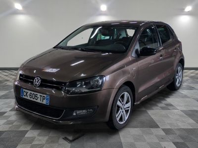 la voiture marron est garée sur un sol en damier dans le garage