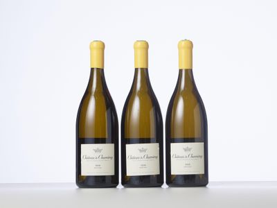 trois bouteilles de vin blanc sont alignées sur une table