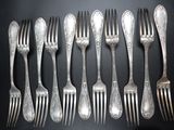 a lot of forks and spoons that are on a table