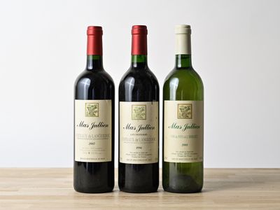 trois bouteilles de vin sont alignées sur une table en bois