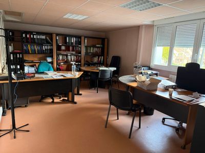 une salle où se trouvent de nombreux bureaux et chaises