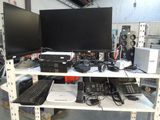two monitors and a keyboard on a shelf in a room