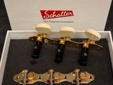 a white box with four gold tone guitar heads in it