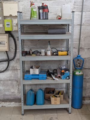une étagère sur laquelle sont posés divers objets, dans un garage