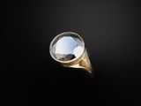 a close up of a gold ring with a faceted diamond
