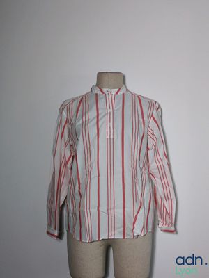 une chemise rayée posée sur un mannequin, devant un mur blanc