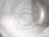 a silver plate with a stamp on it sitting on a table