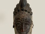 an image of a wooden mask with a chain around it ' s neck
