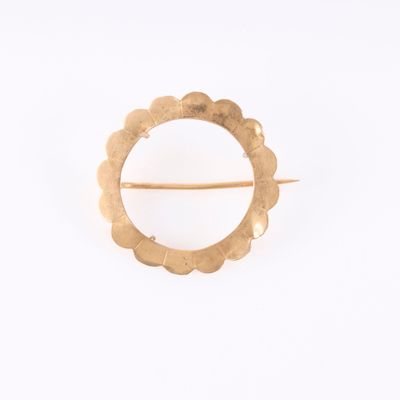 a close up of a gold brooch with a circular design