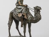 statue représentant une femme à dos de chameau, accompagnée d'un chien en laisse