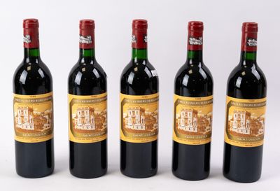 quatre bouteilles de vin sont alignées sur une surface blanche