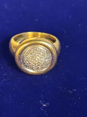 a gold ring with a stone in it on a blue surface