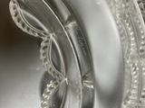 a clear glass ashtray with a curved edge