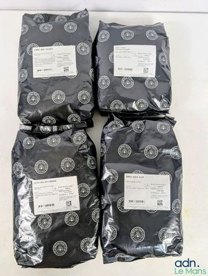 quatre sacs de nourriture noire posés sur une table blanche