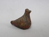 un gros plan d'une figurine d'oiseau posée sur une surface blanche