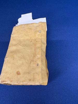 un morceau de papier posé sur une surface bleue, d'où dépasse un autre morceau de papier