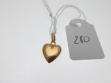 un pendentif en forme de cœur en or auquel est attachée une étiquette de prix