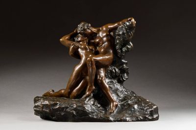 une statue en bronze représentant un homme et une femme assis sur un rocher