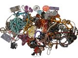 a pile of assorted necklaces and bracelets on a white surface