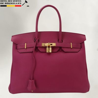un sac Hermès rose avec un fermoir doré sur la poignée