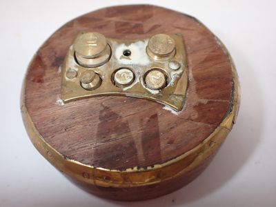 une boîte en bois ornée de boutons, posée sur une table