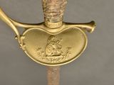 a close up of a gold colored sword with a heart on it