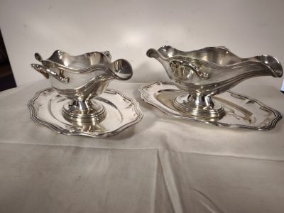pair of silver plated saucers on trays on a table