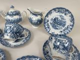 several blue and white plates and cups and saucers on a table