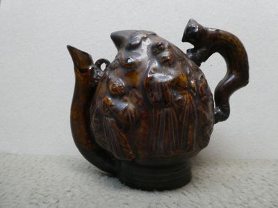 une théière marron ornée d'un chat, posée sur une table