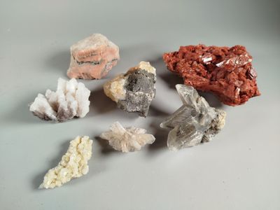 several different types of rocks and crystals on a white surface