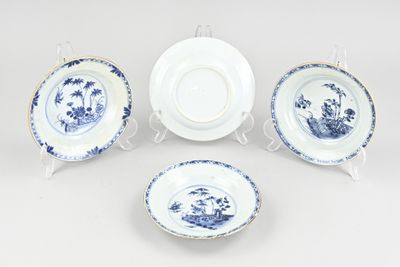 four pieces of blue and white china on a white background