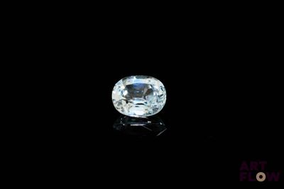 un diamant blanc sur une surface noire, avec un fond noir