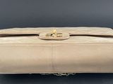 a beige purse with a gold clasp on it