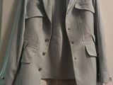 grey jacket hanging on a hanger on a wall