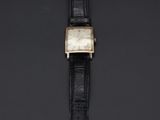 a gold and black watch on a black surface