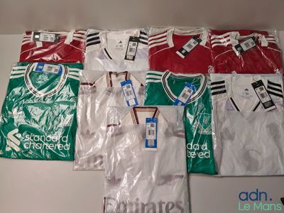 Plusieurs maillots de foot sont rangés dans des sacs en plastique sur une table
