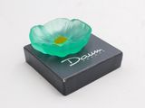 une fleur verte posée sur une boîte noire
