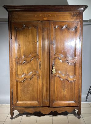 a large wooden cabinet with a door on top of it