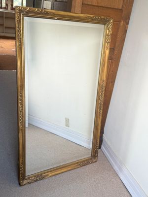 un grand miroir posé par terre dans un coin de la pièce