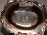 a silver bowl with a label on it on a table