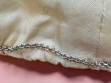 a silver chain that is attached to a white shirt