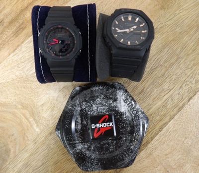 deux montres et un étui à montres posés sur une surface en bois