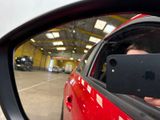 a man taking a picture of himself in the rear view mirror of a car