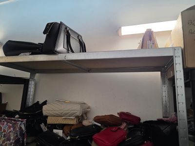 Plusieurs valises sont empilées sur une étagère dans une pièce