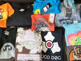 tout un tas de t-shirts posés sur un canapé