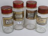 six glass jars with different types of medicine on a white surface